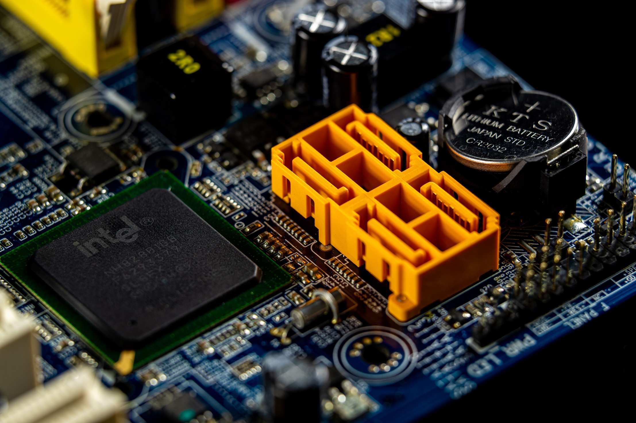 แผงวงจรอิเล็กทรอนิกส์และชิปควบคุม Detailed view of a computer motherboard showcasing an Intel microprocessor
